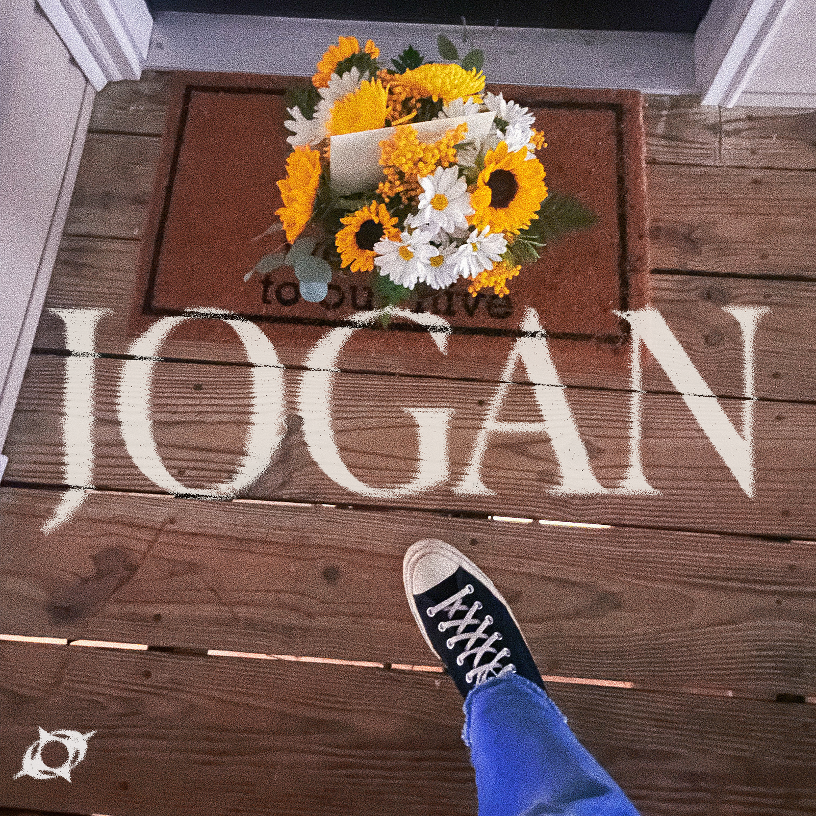 A set of flowers dropped off on a doorstep, with JOGAN text over top of it